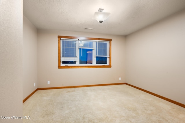 carpeted empty room featuring a textured ceiling