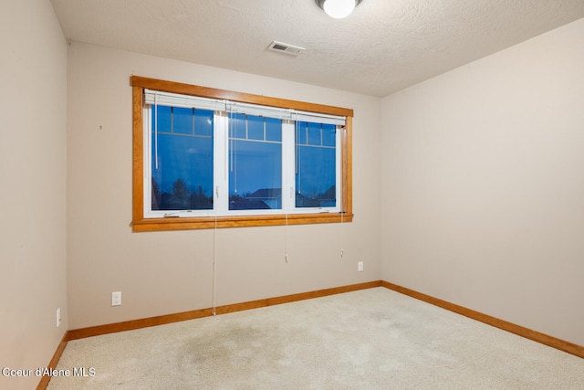 empty room with carpet and a textured ceiling