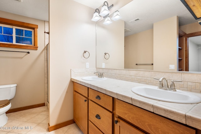 bathroom featuring decorative backsplash, vanity, tile patterned flooring, toilet, and a shower with shower door