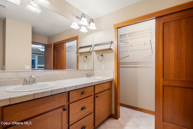 bathroom with vanity, backsplash, and tile patterned flooring