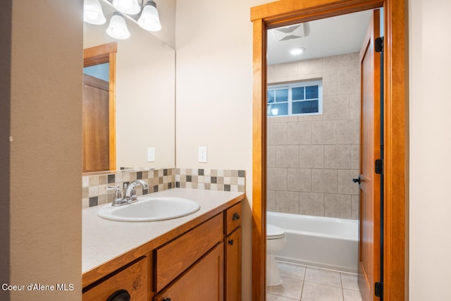 full bathroom featuring vanity, toilet, tile patterned flooring, and tiled shower / bath combo