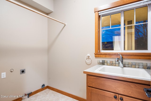 clothes washing area featuring hookup for a gas dryer, sink, cabinets, and hookup for an electric dryer