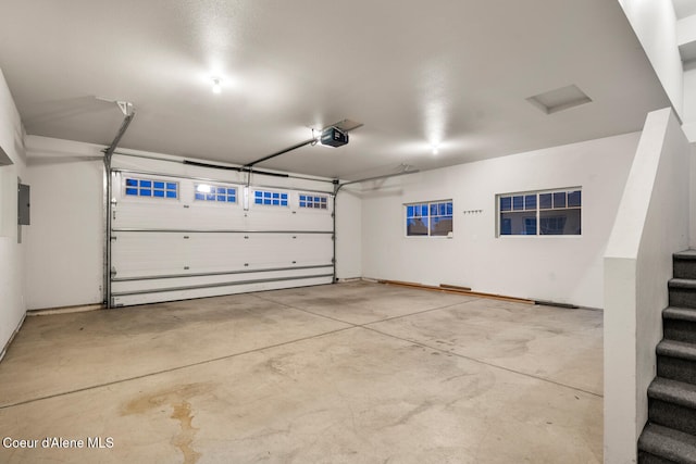 garage with electric panel and a garage door opener