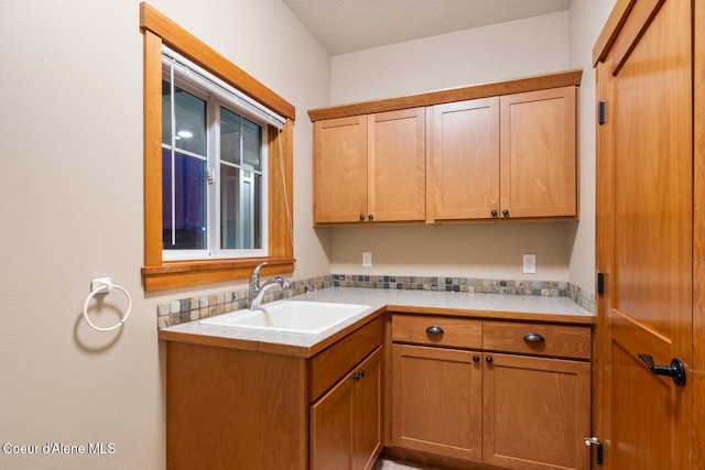 laundry area with a textured ceiling and sink