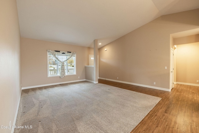 spare room featuring lofted ceiling and hardwood / wood-style flooring