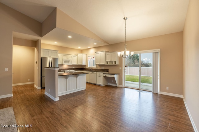 kitchen featuring white cabinetry, dark wood-type flooring, decorative light fixtures, a kitchen island, and appliances with stainless steel finishes