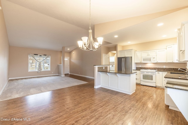 kitchen featuring white appliances, decorative light fixtures, light hardwood / wood-style flooring, white cabinetry, and lofted ceiling