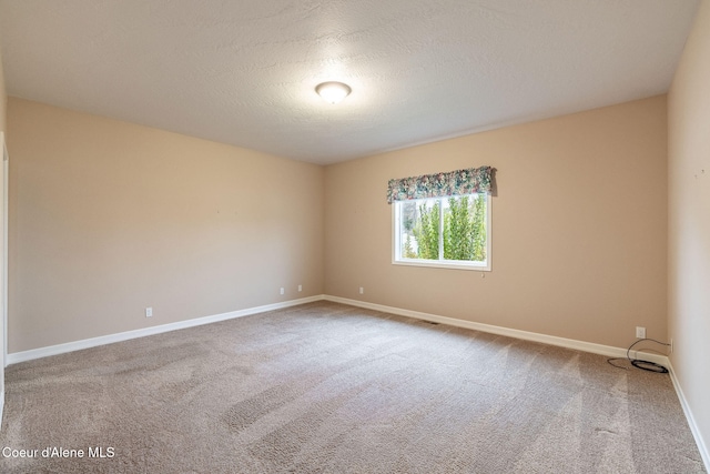 carpeted spare room featuring a textured ceiling