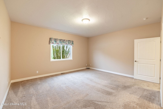 empty room with a textured ceiling and carpet floors