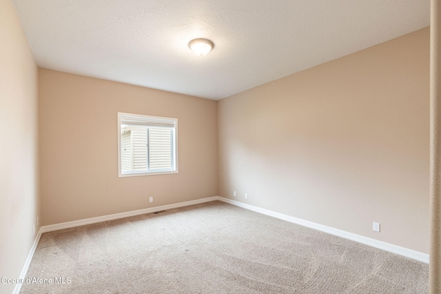 carpeted empty room with a textured ceiling