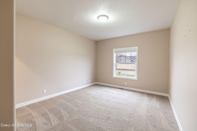 carpeted spare room with a textured ceiling