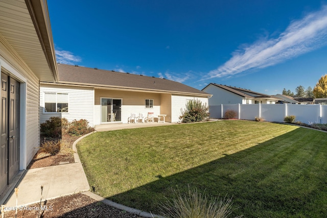 rear view of house featuring a lawn and a patio