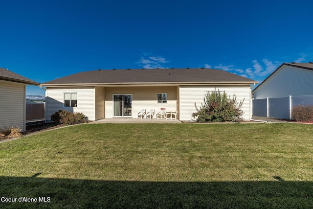 back of property with a yard and a patio