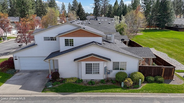 view of front of property with a shingled roof, fence, a front yard, and concrete driveway