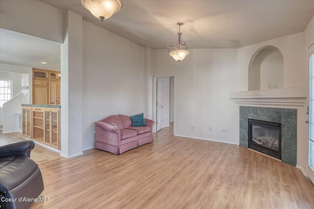 living room featuring baseboards, light wood finished floors, and a fireplace