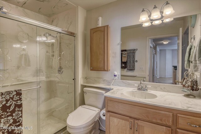 bathroom featuring vanity, a marble finish shower, and toilet