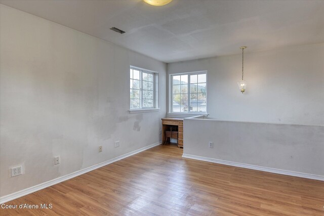 spare room featuring baseboards, visible vents, and light wood-type flooring
