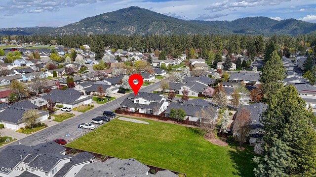drone / aerial view with a residential view, a view of trees, and a mountain view