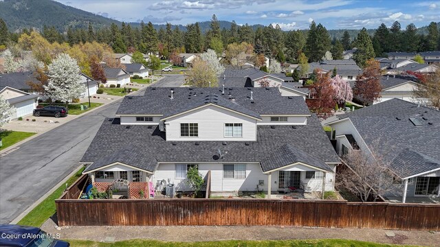 back of house with roof with shingles, fence, and a residential view