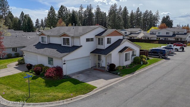 traditional-style house with a front lawn, fence, roof with shingles, driveway, and a residential view