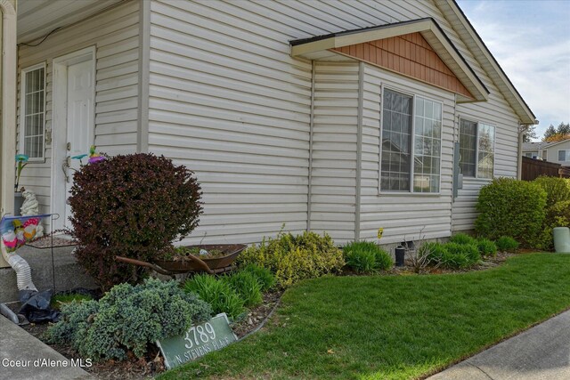 view of side of property featuring a lawn and crawl space