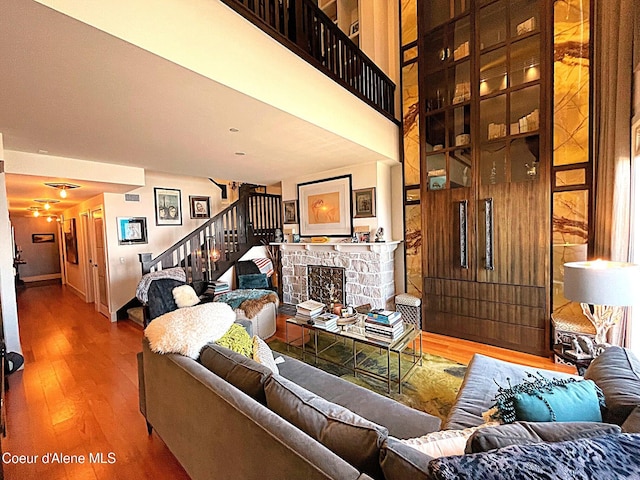 living room featuring hardwood / wood-style flooring and a stone fireplace