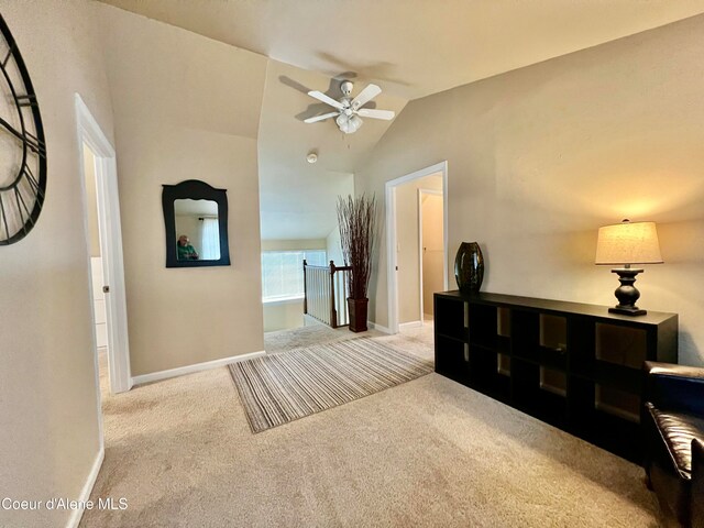 hallway featuring light colored carpet and lofted ceiling