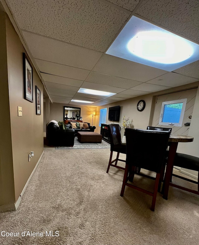 carpeted dining room with a drop ceiling