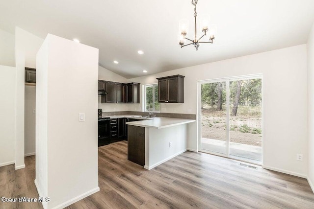 kitchen with light hardwood / wood-style floors, black electric range oven, and hanging light fixtures