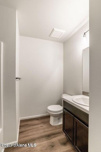 bathroom with hardwood / wood-style floors, vanity, and toilet