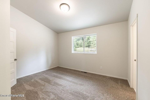 unfurnished room with carpet flooring and vaulted ceiling