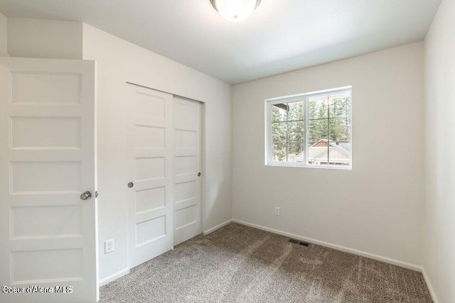 unfurnished bedroom featuring a closet and carpet floors