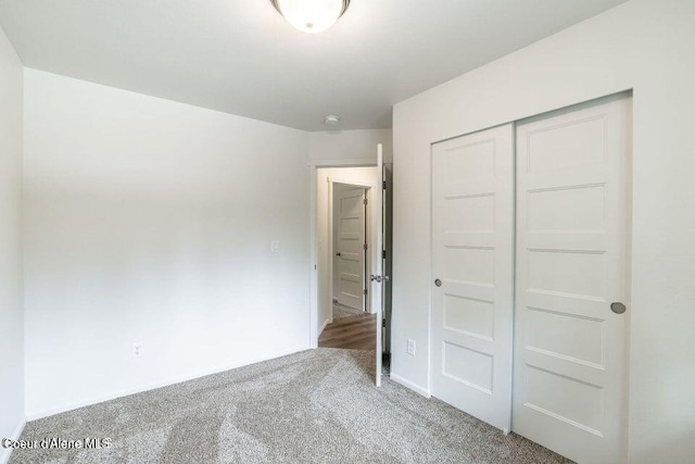 unfurnished bedroom with a closet and carpet floors