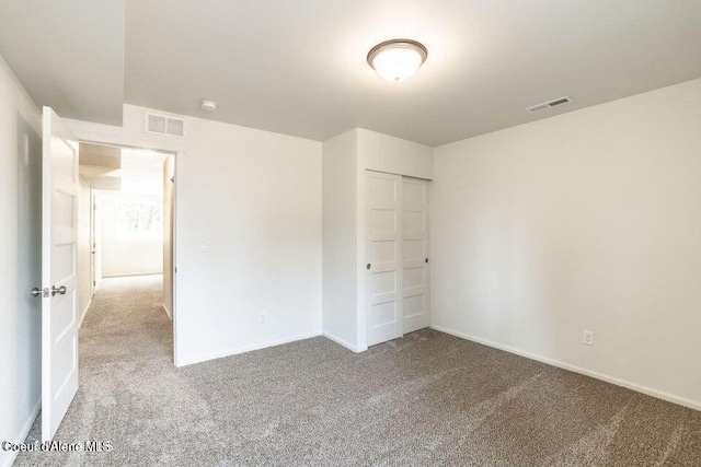 unfurnished bedroom featuring carpet flooring and a closet