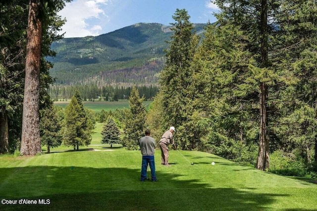 surrounding community with a mountain view and a lawn