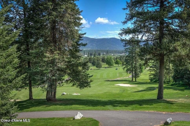 surrounding community with a lawn and a mountain view