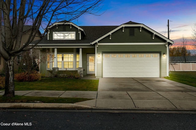 view of front of property featuring a lawn, concrete driveway, and a garage