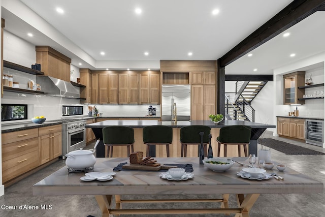 kitchen with range hood, open shelves, stainless steel built in fridge, dark countertops, and beverage cooler
