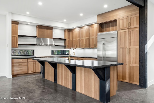 kitchen featuring concrete floors, built in refrigerator, open shelves, and exhaust hood