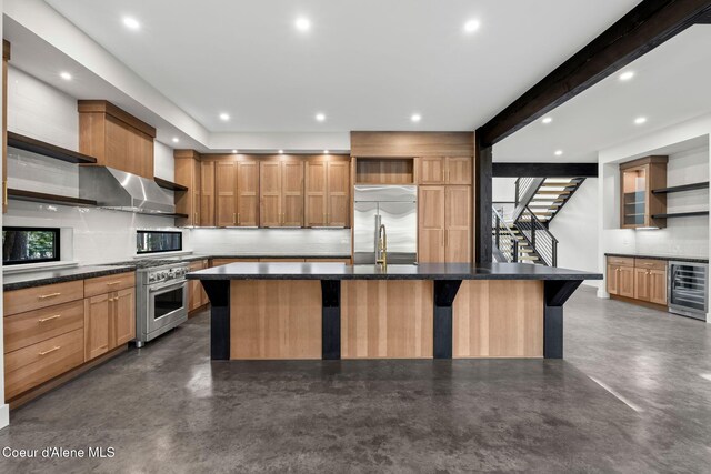 kitchen featuring concrete floors, open shelves, appliances with stainless steel finishes, a center island with sink, and beverage cooler