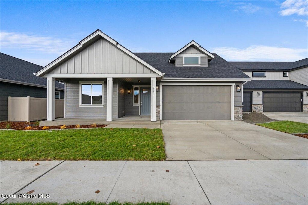 view of front facade featuring a porch, a front yard, and a garage