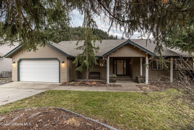 view of front facade featuring central AC, a garage, and a front lawn