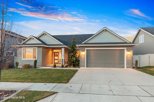 view of front of home with a garage and a lawn