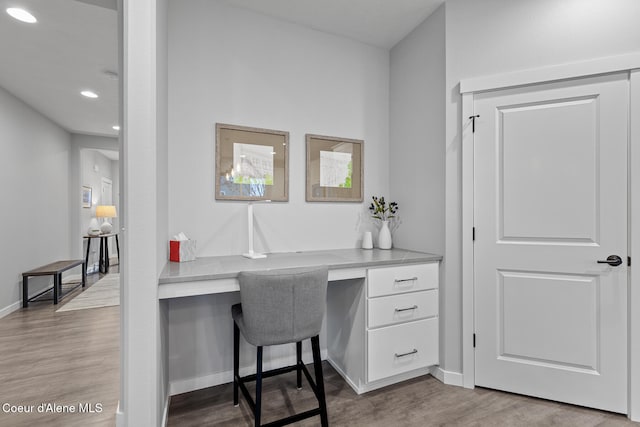 home office featuring built in desk and light wood-type flooring