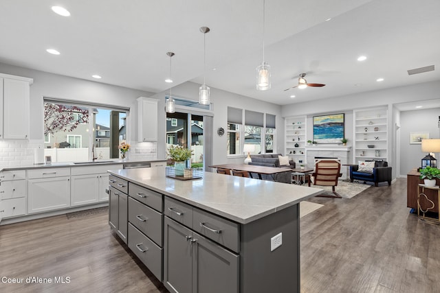 kitchen featuring white cabinetry, ceiling fan, and a healthy amount of sunlight