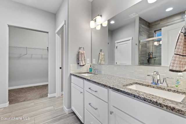 bathroom featuring decorative backsplash, vanity, hardwood / wood-style flooring, and a shower with door