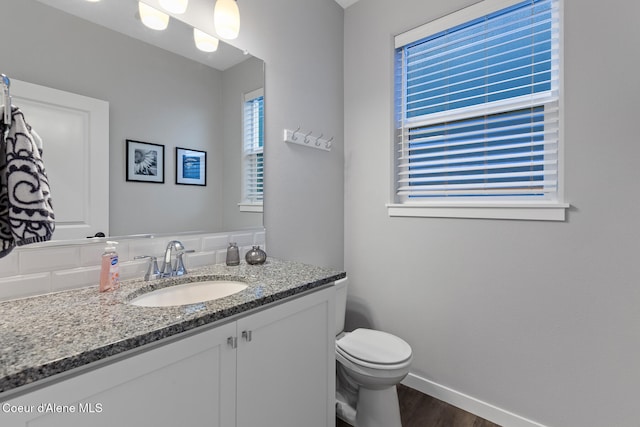 bathroom with hardwood / wood-style flooring, vanity, and toilet