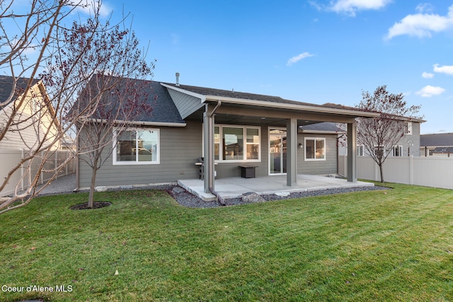 back of property with a yard and a patio area