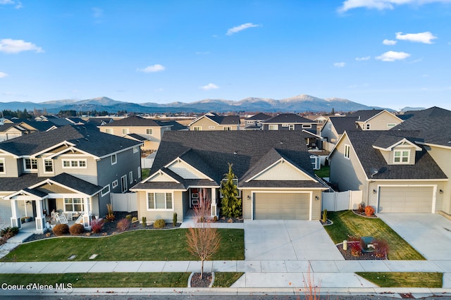 view of front facade with a mountain view, a front lawn, and a garage