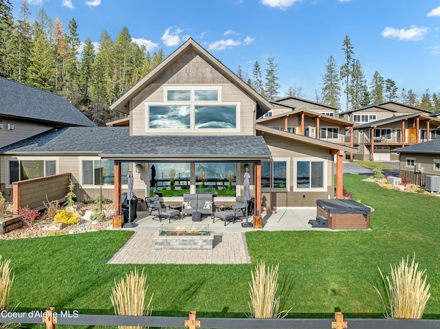 rear view of property featuring central AC unit, a yard, a patio, and a hot tub